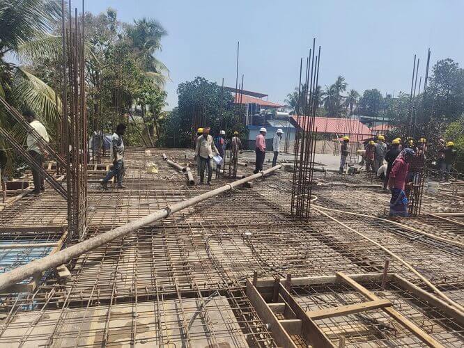 Men are working with the structure using steel rods.