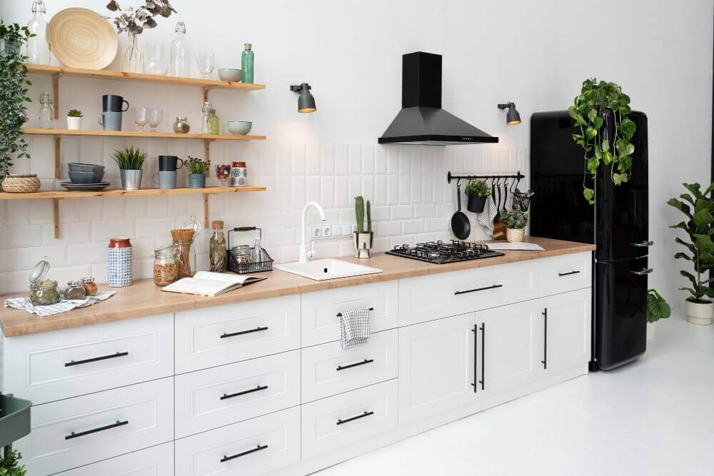 Minimalist kitchen with white cabinets, marble accents, and pendant lights.