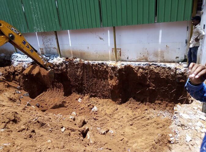 Excavator digging out mud to make space.